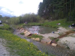 V rybníku Termálny prameň pláva skupinka ľudí.