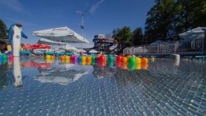 Aquapark Turčianske Teplice ponúka bazén s farebnými loptičkami a slnečníkmi.