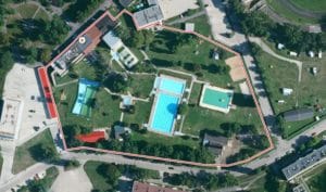 Letecký pohľad na Termálne kúpalisko v Komárne s bazénom a tenisovým kurtom.