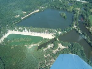 Letecký pohľad na Prírodné kúpalisko Gazárka Šaštín-Stráže, jazero obklopené lesom.