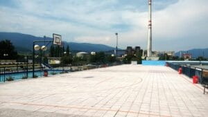 Letné kúpalisko Sunny Martin ponúka prázdne basketbalové ihrisko s majestátnymi horami v pozadí.