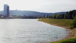 Veľká vodná plocha Jazero Kuchajda pri kopci v Bratislave.