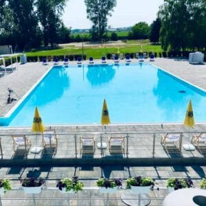Letné kúpalisko Modrá Perla vo Veľkých Úľanoch ponúka veľký bazén s ležadlami a slnečníkmi.