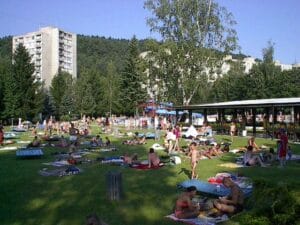 Veľká skupina ľudí, ktorí si užívajú chvíle na Letnom kúpalisku Považská Bystrica.