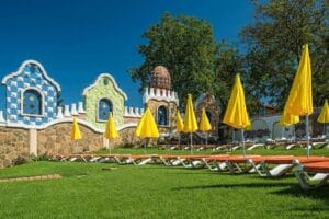 Letné kúpalisko Plaza Beach Prešov ponúka malebný trávnik so stoličkami a slnečníkmi pred majestátnym zámkom.