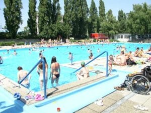 Letné kúpalisko na bratislavskom Tehelnom poli, rušné množstvom ľudí, ktorí si užívajú veľké kúpalisko.