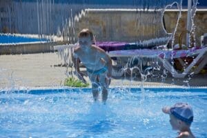 Dve deti hrajúce sa v bazéne na Letnom kúpalisku.