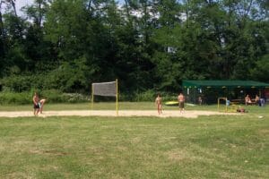Partia ľudí hrá volejbal na Letnom kúpalisku Bojnice.