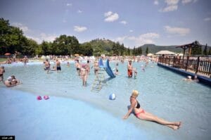Partia ľudí, ktorí si užívajú leto na Letnom kúpalisku Žiar nad Hronom.