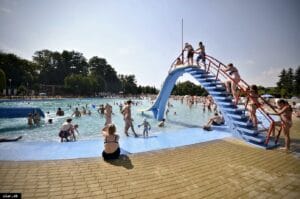 Partia ľudí si užíva Letné kúpalisko Žiar nad Hronom so šmykľavkou.