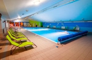 Veľký krytý bazén s ležadlami v krásnom meste Terchová, kde si návštevníci môžu oddýchnuť a vychutnať si omladzujúci zážitok z Termálneho kúpaliska.