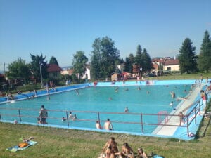 Letné kúpalisko Višňové ponúka pulzujúcu atmosféru, keď si partia ľudí užíva kúpanie v bazéne.