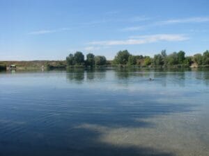 Prírodné kúpalisko Jazero Rovinka, pokojná vodná plocha v malebnej krajine.