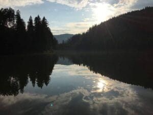 Slnko jemne osvetľuje panenské vody Prírodného kúpaliska jazera Uhorná Smolník.