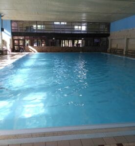Krytá plaváreň v hoteli Javorná s veľkým krytým bazénom v budove.