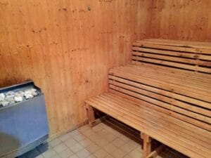 Drevená sauna s lavičkami a vedrom, ktorá sa nachádza v Krytá plaváreň Veľký Krtíš.