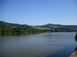 Vodná priehrada Ružín - Západ Margecany je malebná krajina vodnej plochy s horami v pozadí.