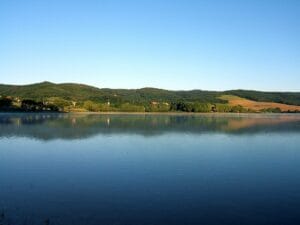 Vodná nádrž Ružiná, jazero obklopené kopcami a stromami.