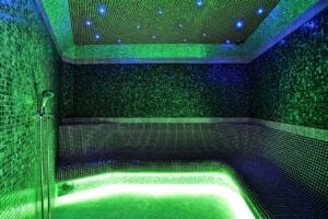Kúpeľňa so zeleným obkladom a zeleným svetlom v Krytá plaváreň Bardejov.