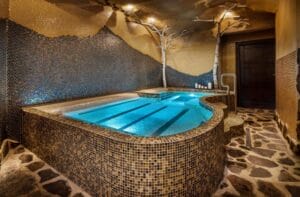 Luxusná kúpeľňa v hoteli Aqua Paradise Grand s vírivkou obklopenou stenami s krásnymi dlaždicami.