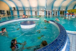 Veľký aquapark s množstvom ľudí, ktorí si užívajú krytý bazén v hoteli Aqua Relax v Sorea Titris Tatranská Lomnica.