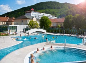 Skupina ľudí v Termálnych bazénoch Trenčianske Teplice, ktorí si užívajú zážitok v Kúpeľoch.