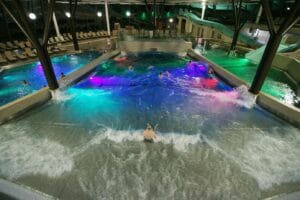 Veľký krytý bazén, v ktorom plávajú ľudia v Aquaparku.